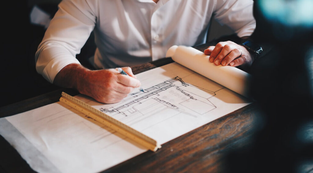 architecte dessinant les plans pour la rénovation d'un appartement parisien